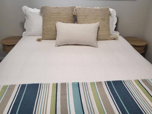 麦夸里港Coastal Pod的一张带两个枕头和白色床罩的床
