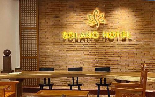 利帕Solano Hotel & Resort At Casa Ysabel的餐厅设有木桌和砖墙