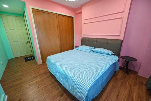 古晋Santubong Suites Lower Level的粉红色和绿色墙壁的房间里一张床位