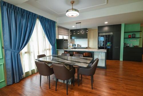 古晋Santubong Suites Lower Level的一间带桌椅的用餐室和一间厨房