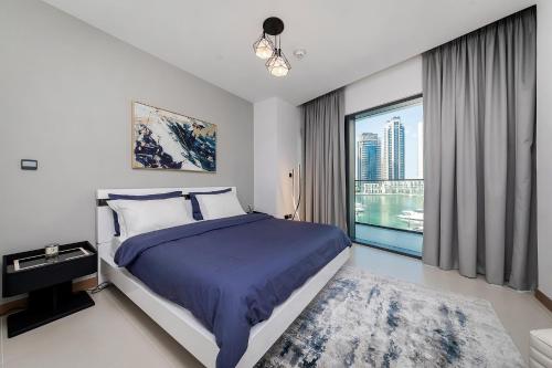 迪拜Luxurious 2BR apt with panoramic Marina view的一间卧室设有一张床和一个大窗户