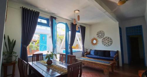 布莱伦Rumah Batu的一间带桌子和蓝色沙发的用餐室