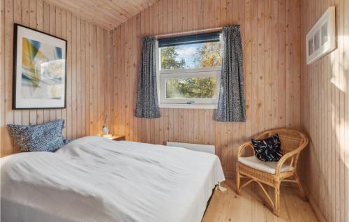 NordbyBeautiful Home In Sams With Kitchen的一间卧室设有一张床、一个窗口和一把椅子