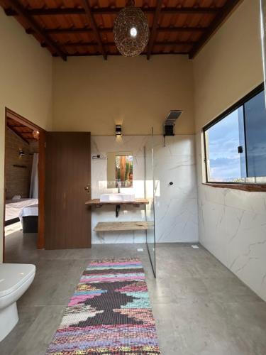 圣若热岛Chalé Pousada Maná do Céu - São Jorge的带淋浴和卫生间的浴室以及地毯。