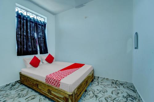 巴特那OYO Flagship Your Room & Guest House的一间卧室配有一张带红色枕头的床和一扇窗户