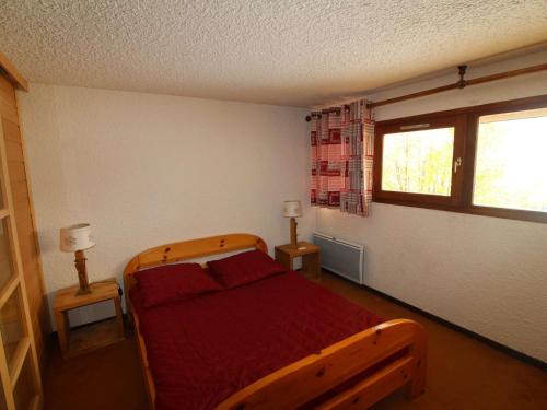 奥瑞斯Appartement Auris, 3 pièces, 8 personnes - FR-1-297-337的一间卧室配有一张带红色床单的木床和窗户。