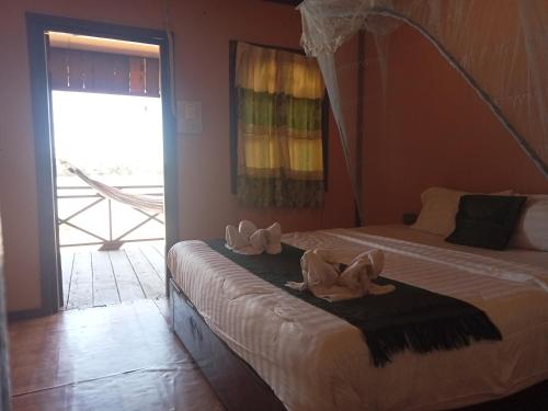 Muang KhôngChampa Guesthouse的一间卧室配有两张床,床上配有毛巾