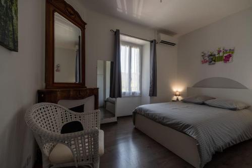 GénérarguesGite Oustalet avec piscine & SPA的一间卧室配有一张床、镜子和椅子