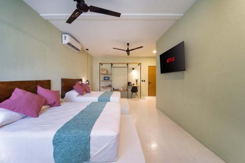 圣克鲁斯华特库Hotel Bindani’的配有两张床铺的客房,墙上配有电视