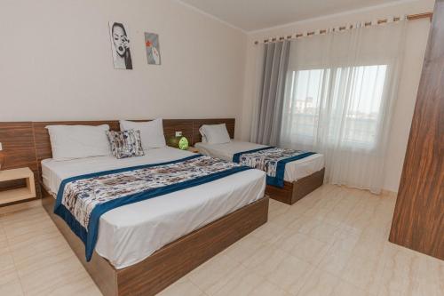 赫尔格达Andalusia Blue Beach Hurghada的酒店客房设有两张床和窗户。