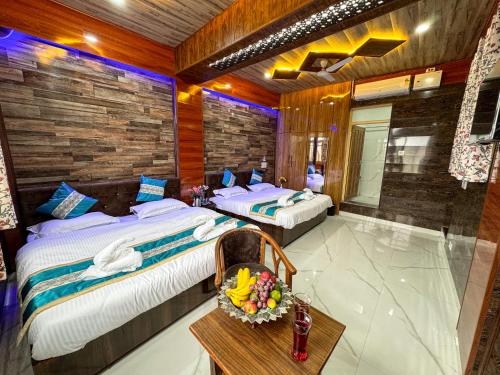 斯利那加Aasariya Hotel And Restaurants的酒店客房设有两张床和一张桌子。