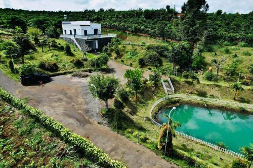 保禄Homestay Nhà Của Gạo的享有山丘上房屋的空中景致,设有游泳池
