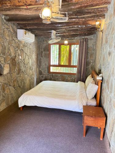 Bīmahbait bimah travel lodge的卧室配有一张石墙床