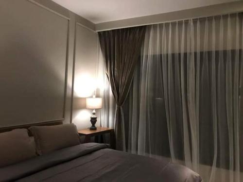 纳闽巴霍Hotel Sanset的一间卧室配有一张床和一扇带灯的窗户