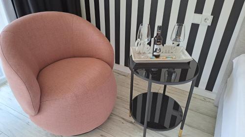 基姆高地区阿绍Apartment Kampenwand的边桌边的粉红色椅子和酒杯