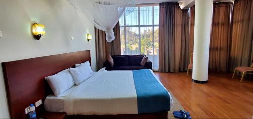 巴赫达尔Yiganda Hotel - Ethiopia的酒店客房设有一张床和一个大窗户