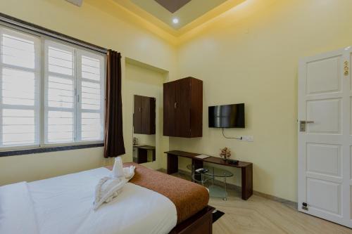 潘奇加尼Silver Galaxy Resort的一间卧室配有一张床、一个窗口和一张书桌