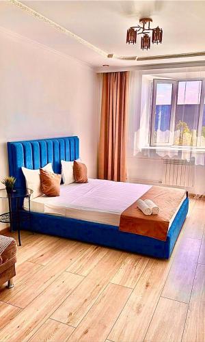 科克舍套Аблайхана 1/3的一间卧室配有一张大床和蓝色床头板