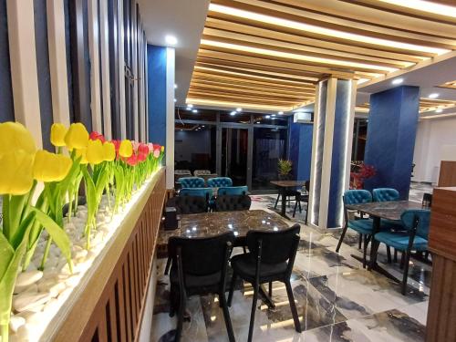 伊斯坦布尔White Palace Hotel的餐厅墙上挂着桌椅和鲜花