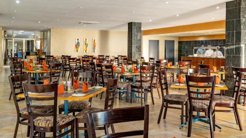 埃尔默洛African Sky Ermelo Inn的餐厅内带桌椅的用餐室