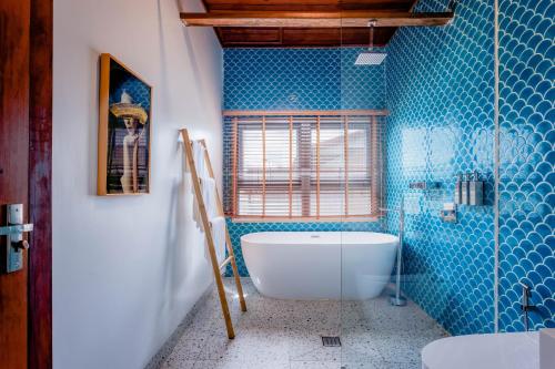 Kaoh SdachKoh Apikjun Resort的带浴缸和蓝色瓷砖的浴室