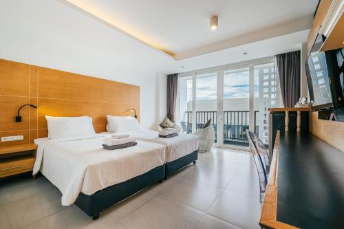 卡马拉海滩Vivace Hotel的一间带大床的卧室和一个阳台