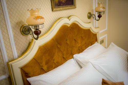 锡比乌Cochet House Sibiu的一张床上,上面有金色床头板