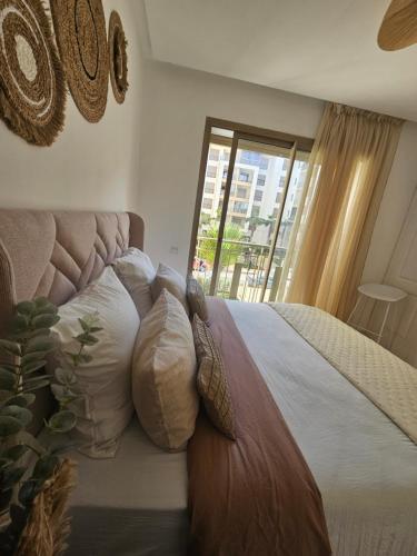 NouaceurAirport Break的卧室配有带枕头的床铺和窗户。