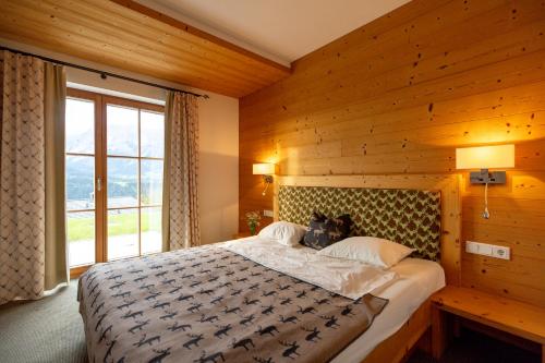 斯拉德明Chalet Bergmueller的一间卧室设有一张带木墙的大床