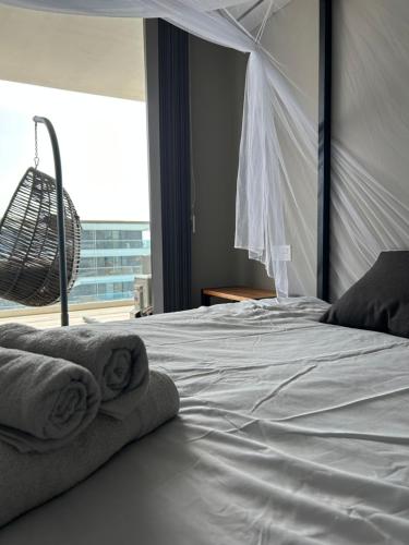 Sere KundaFar Out Apartments - Kololi Sands的卧室配有白色床和毛巾
