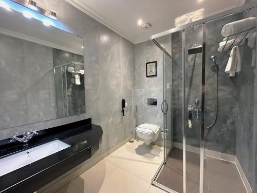 克久拉霍A S Hotels的带淋浴、卫生间和盥洗盆的浴室
