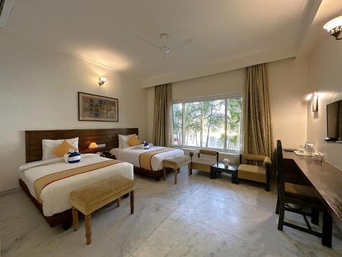 克久拉霍A S Hotels的酒店客房设有两张床和窗户。