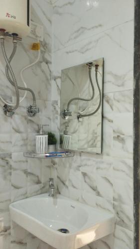 马尔万आंगण होम स्टे的白色的浴室设有水槽和镜子