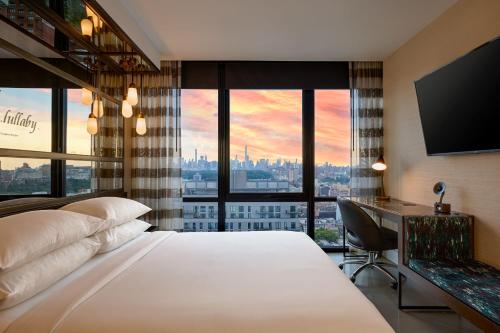 纽约Renaissance New York Harlem Hotel的酒店客房设有一张床和一张书桌,享有美景。