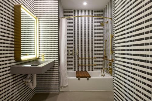 纽约Renaissance New York Harlem Hotel的浴室配有水槽、淋浴和浴缸。