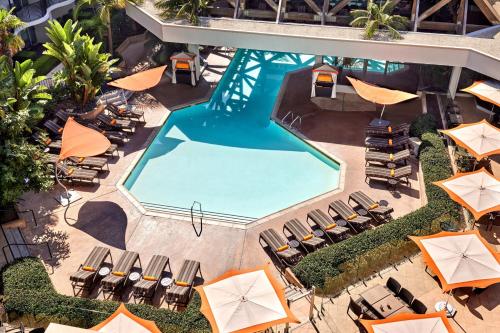 安纳海姆阿纳海姆万豪酒店的享有带椅子和遮阳伞的游泳池的上方景致