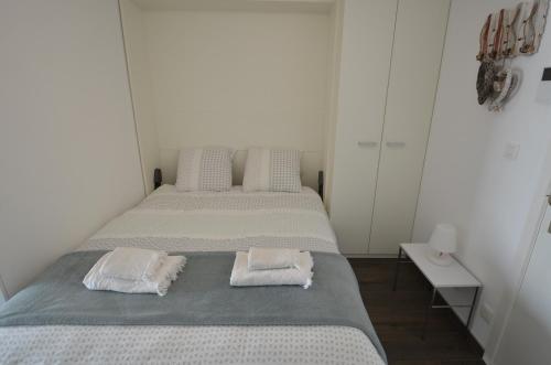 米德尔克尔克An's seaview Middelkerke的白色客房的两张床和毛巾