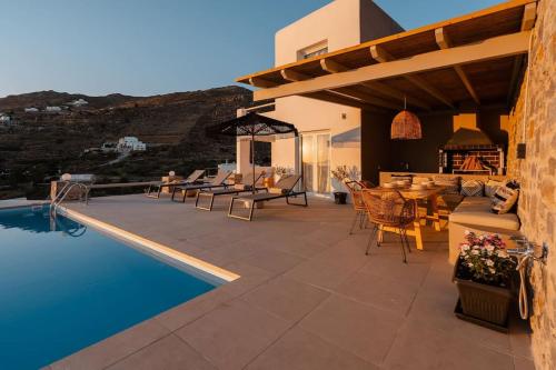 AgkidiaPleiades Villas Naxos2 (Hottub)的一个带桌椅的庭院和一个游泳池