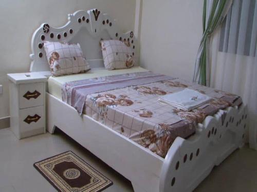 SaréCentre Ecotouristique de Bagré的卧室配有白色的床和木制床头板