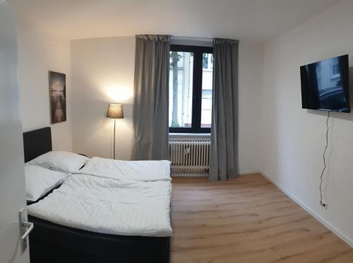 鲁尔河畔米尔海姆Studio Apartments in Ruhrgebiet的一间卧室配有一张床和一台电视