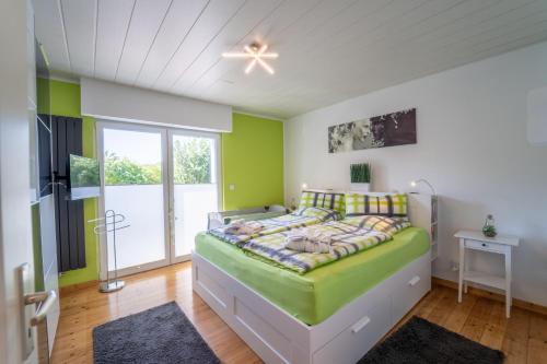 科布伦茨Ferienvilla Koblenz的一间设有床铺的卧室,位于一个拥有绿色墙壁的房间