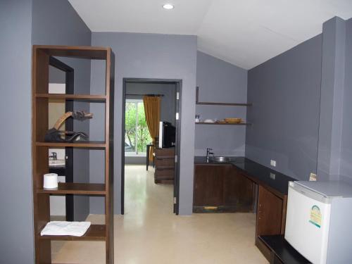 苏梅岛Mindful Kinesics Wellness Living的一间拥有蓝色墙壁和木制架子的厨房