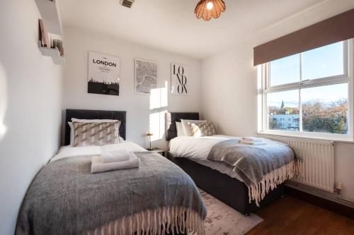 南安普敦Highland - 2 Bedroom Flat with Parking的一间卧室设有两张床和窗户。