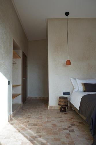 依索安L'Oued the lodge的一间卧室配有一张床和吊灯