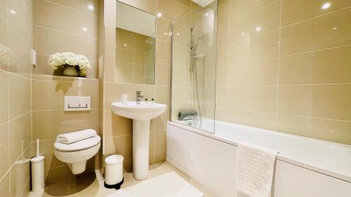 恩菲尔德Urban Gem Apartment- Free parking的浴室配有盥洗盆、卫生间和浴缸。