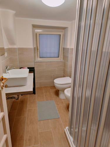 卡塔尼亚Capuana House的一间带卫生间、水槽和窗户的浴室
