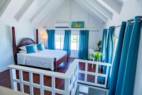 BelmontBay House Grenada的一间拥有蓝色窗帘的卧室和一张位于客房内的床