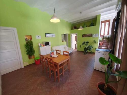 韦斯卡尔Vivienda Rural Embalse San Clemente的客厅设有木桌和绿色墙壁。