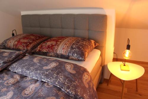 萨尔茨堡Junker's Apartments的一间卧室配有两张带枕头和桌子的床