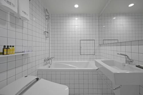 首尔明洞克莱托酒店的浴室配有2个盥洗盆、卫生间和浴缸。